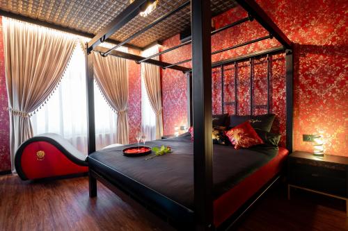a bedroom with a canopy bed with red walls at Apartament Organza - Private Gym - Spa - Free Parking in Toruń