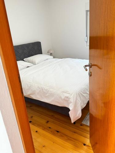a bedroom with a bed with white sheets at Vele apartment in Mostar