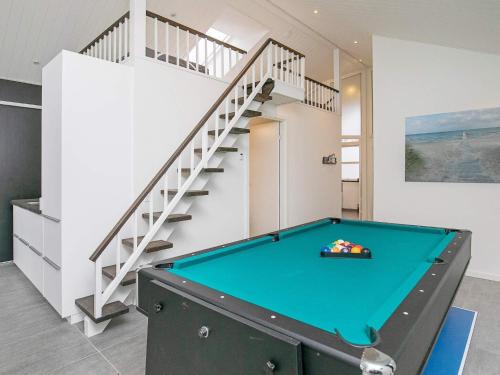a pool table in a room with a staircase at 5 star holiday home in Jerup in Jerup