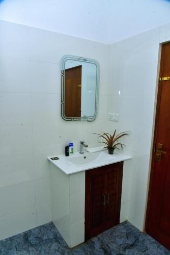 a white bathroom with a sink and a mirror at Vaaru Beach Villa in Kosgoda