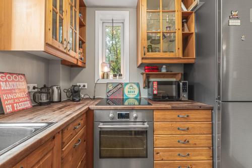 a kitchen with wooden cabinets and a stainless steel oven at Cosy Haven Apartment in Reykjavík