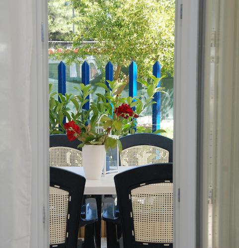 a table with chairs and a vase with flowers on it at Thalassenia Studios & Apartments 3 in Hanioti