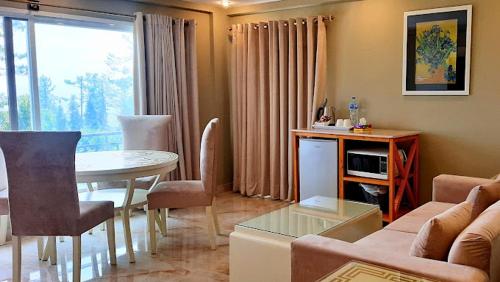 a living room with a couch and a table at The Mont Calm Suites in Dargai