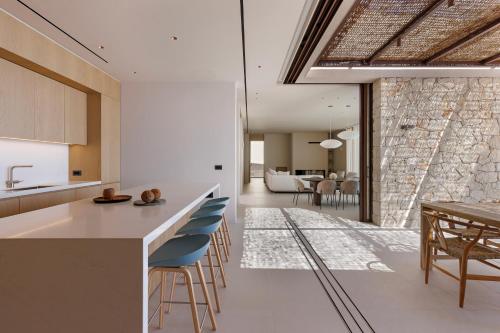 a kitchen and dining room with a table and chairs at Celestia Cove, Earthy Architecture Meets Endless Blue by etouri 