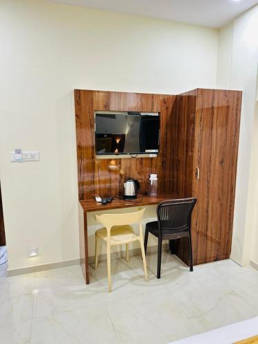 a room with a table and two chairs and a television at Hotel Imperial inn in Mumbai
