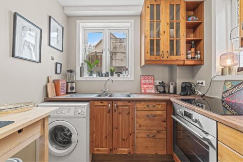a kitchen with a sink and a washing machine at Cosy Haven Apartment in Reykjavík