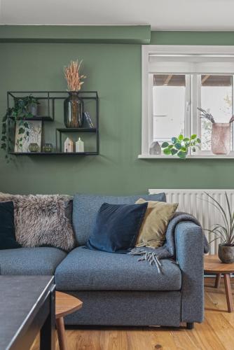 a living room with a blue couch and a window at Cosy Haven Apartment in Reykjavík