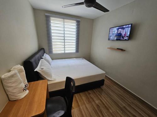 スバン・ジャヤにあるI Go Hotel USJのベッドとテーブルのある小さな部屋