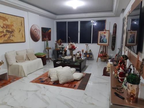 una sala de estar con un sofá y una mesa en TÔ em casa Barra Porto, en Salvador