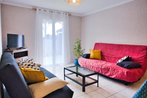 a living room with a red couch and a tv at Family house with beautiful garden in Saint-Hippolyte