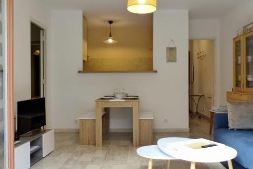 Apartment of 36 m2 with terrace في ساناري سور مير: غرفة معيشة مع طاولة وأريكة زرقاء