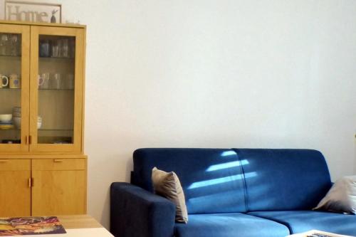 Apartment of 36 m2 with terrace في ساناري سور مير: أريكة زرقاء في غرفة المعيشة مع خزانة