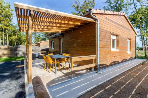 a small cabin with a table and chairs on a deck at Gite 1 de l'Orée du Bois in Thenon