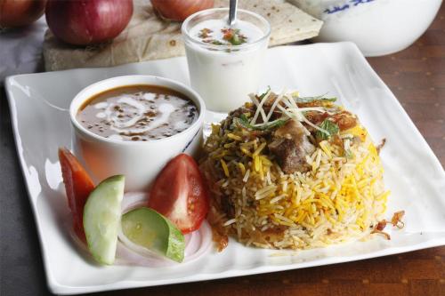 a plate of food with rice and a cup of soup at Radisson Blu Gorakhpur in Gorakhpur