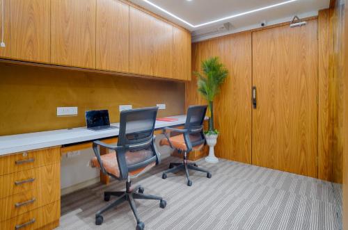 an office with two chairs and a desk with a laptop at HOTEL SHITAL INN in Ahmedabad