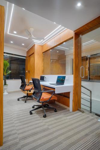 an office with two chairs and a desk with a laptop at HOTEL SHITAL INN in Ahmedabad