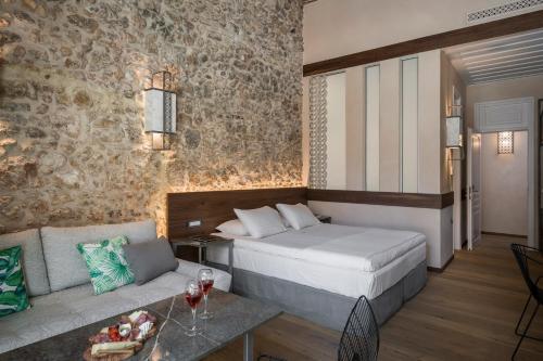 a hotel room with a bed and a couch at Ambassadors Residence Boutique Hotel in Chania Town