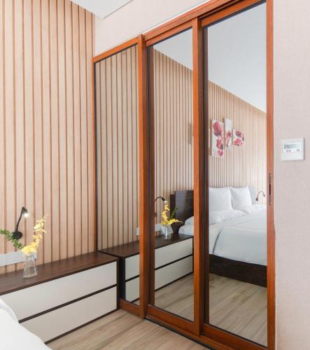 a bedroom with a large mirror and a bed at Emerald Bay Hotel & Spa Nha Trang in Nha Trang