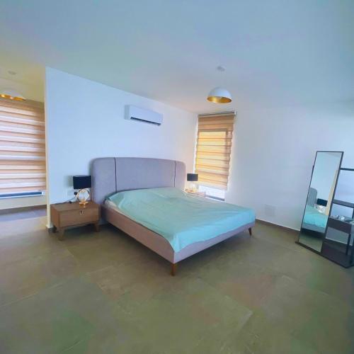 a bedroom with a bed and a mirror in it at Azure Pearl Oceanfront Loft Apartment Spacious Rooftop Terrace Pool in Küçükerenköy