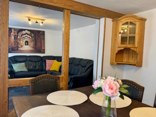 a dining room with a table and a couch at Rhaunen Gasthaus in Rhaunen