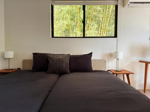 a bedroom with a large bed with a window at VILLA PINECOVE - Vacation STAY 24656v in Kamogawa