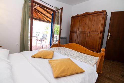 a bedroom with a bed with white sheets and a window at House Bianca with garden in Malinska