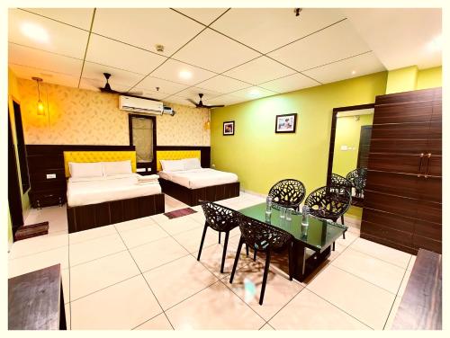 a room with a bed and a table and chairs at Hotel Pearl Royal # Crown Puri Near Jagannath Temple & Puri Beach # Fully Air Conditioning #Restaurant -Free Wi-Fi # Parking -Top Rated Hotel In Puri in Puri
