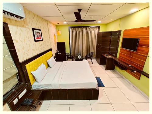 a hotel room with a bed and a television at Hotel Pearl Royal # Crown Puri Near Jagannath Temple & Puri Beach # Fully Air Conditioning #Restaurant -Free Wi-Fi # Parking -Top Rated Hotel In Puri in Puri