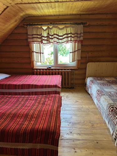 two beds in a log cabin with a window at Садиба Урочище Луг in Vorokhta