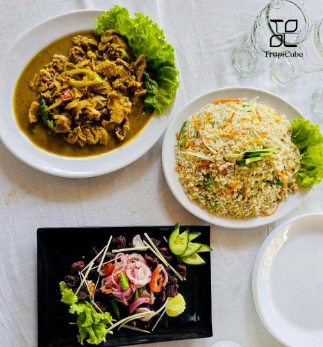 a table with three plates of food on it at Lake View Resort by TropiCube in Pamunugama
