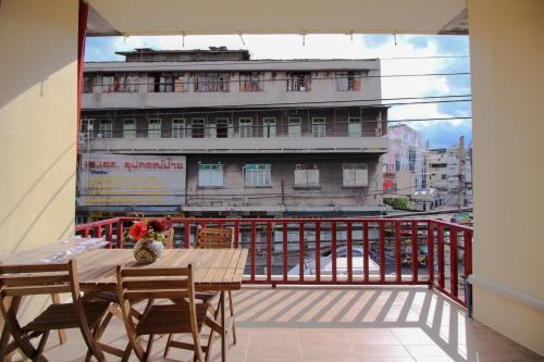 a balcony with a table and chairs and a building at The Open House Cafe and Hostel in Bangkok