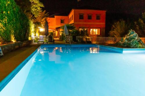 a swimming pool at night with blue lights at Hotel Rural Don Burguillo in El Tiemblo