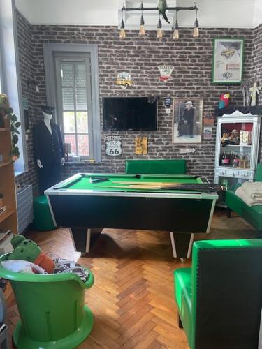 a room with a pool table and a man in a suit at Chambres dans maison de centre ville in Douai