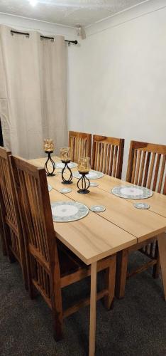 a wooden table with chairs around it in a room at Tartan Nest- Entire house- Sleeps 8 guests in Mansewood