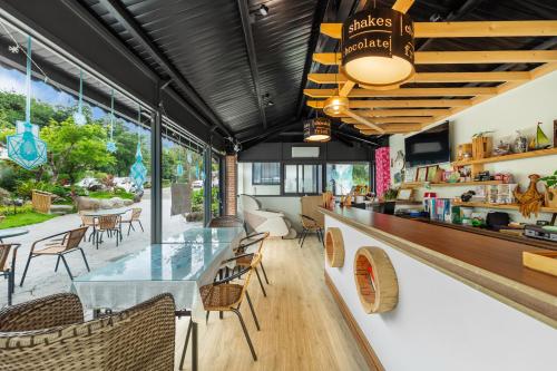 a restaurant with a counter with chairs and tables at 米堤園民宿 in Nanzhuang