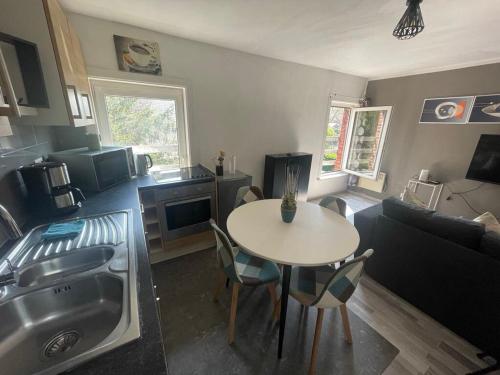 a kitchen and living room with a table and a couch at Petit nid doué in Frameries