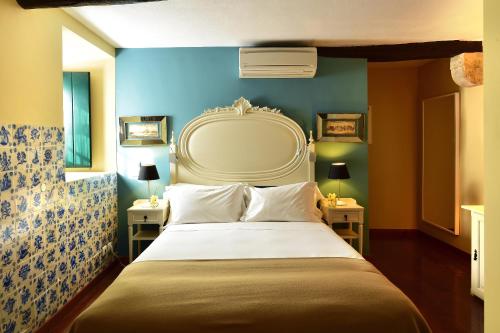 - une chambre avec un grand lit et un mur bleu dans l'établissement Pousada Castelo de Obidos, à Óbidos