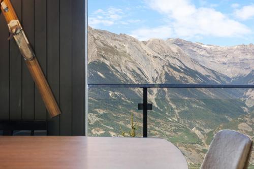 a table and chairs with a view of a mountain at Kool Kabin - 8 pers - vue, charme et confort in Plan Fey