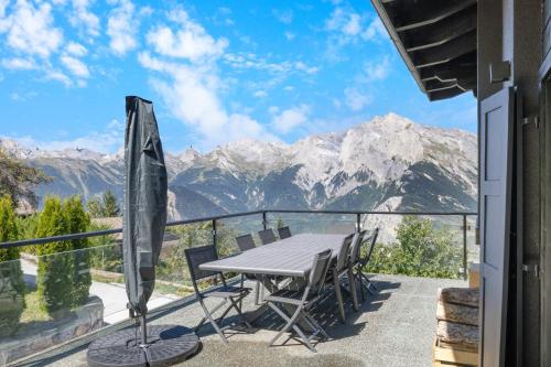 a table and chairs on a balcony with mountains at Kool Kabin - 8 pers - vue, charme et confort in Plan Fey