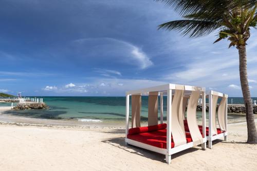 a chair on the beach next to a palm tree at Grand Muthu Runaway Bay Club Caribbean in Runaway Bay