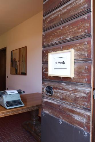 Una pared de madera con un escritorio con una computadora encima. en Il cortile, en San Zenone al Lambro