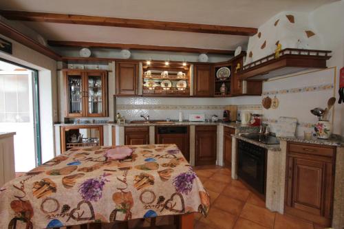 a kitchen with a table with a blanket on it at O Cantinho da Rosa in Casal Lourenço