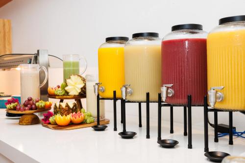 Una fila de botellas de jugo en un mostrador con fruta. en Hotel Inmood San Roque, en Sotogrande