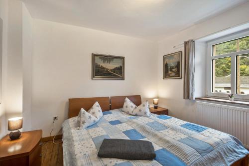 a bedroom with a bed and a window at Ferienhaus Eifellandhaus in Zweifelscheid