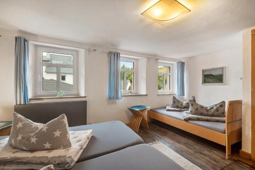 a living room with a couch and two windows at Ferienhaus Eifellandhaus in Zweifelscheid