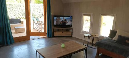 a living room with a couch and a tv at Le refuge barbezien in Lombez