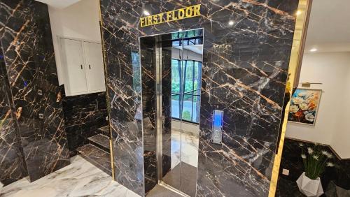 a bathroom with a shower with a black marble wall at Skyline Hotel in Sargodha