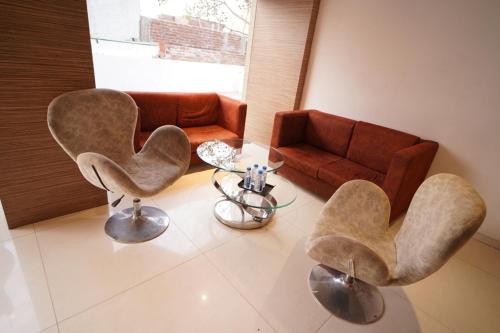 a living room with two chairs and a couch at HOTEL AMORA - Rajnandgaon in Rāj Nāndgaon