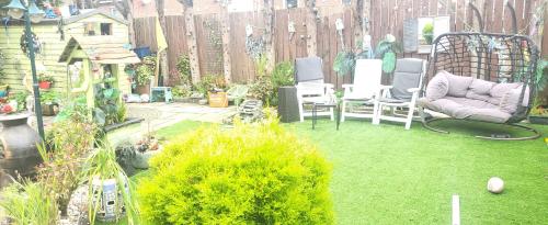a backyard with chairs and grass and a fence at PATs in Belfast