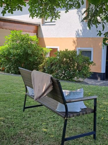 a wicker chair sitting on the grass in a yard at Ferienhaus Hörbach - Die kleine Auszeit in Herborn